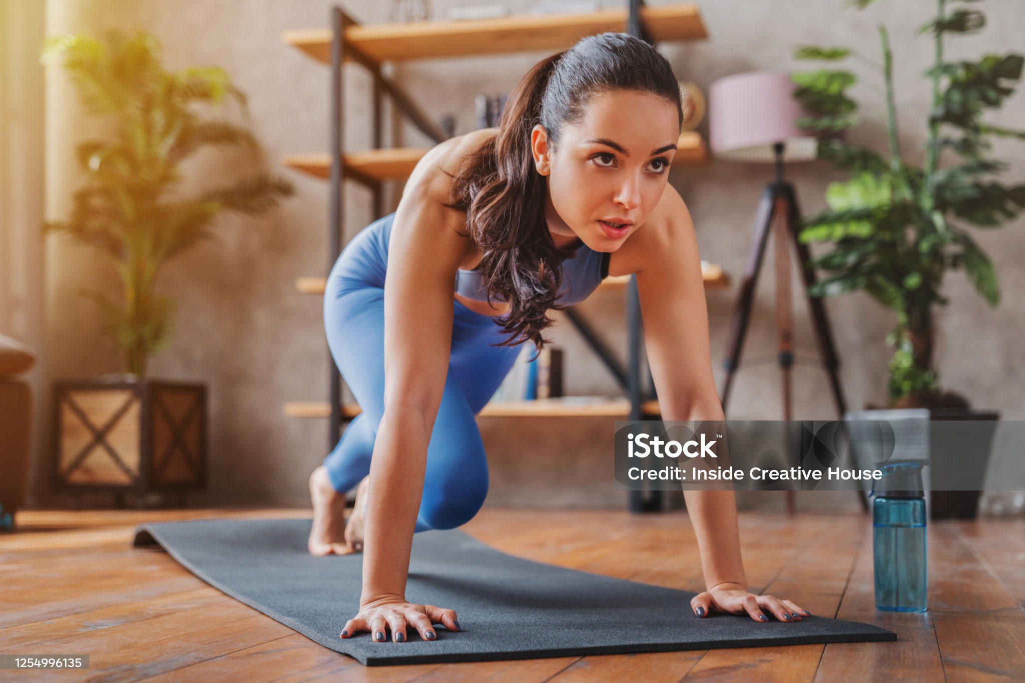 young woman doing sport exercises indoor at home